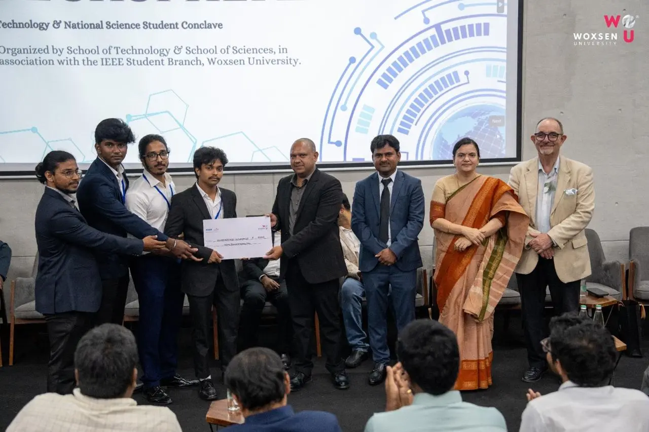 The team receives its TechSphere 2026 award on stage at Woxsen University.