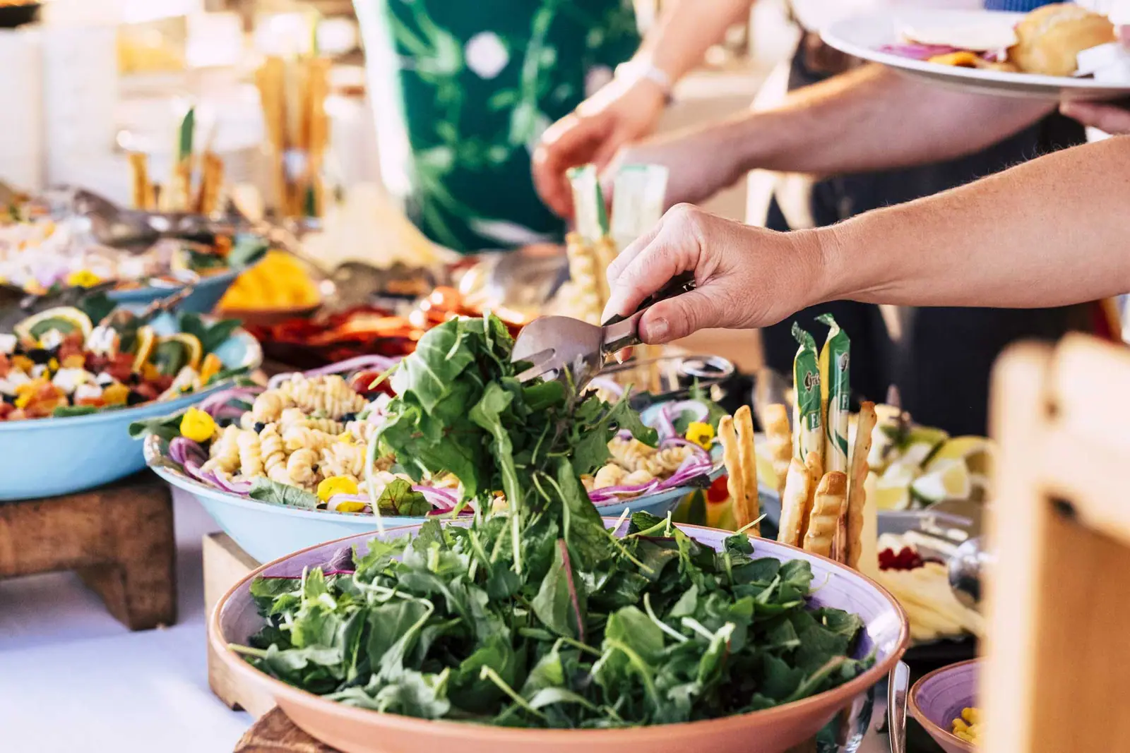 Avala Catering staff preparing a colourful salad and buffet spread for an event.