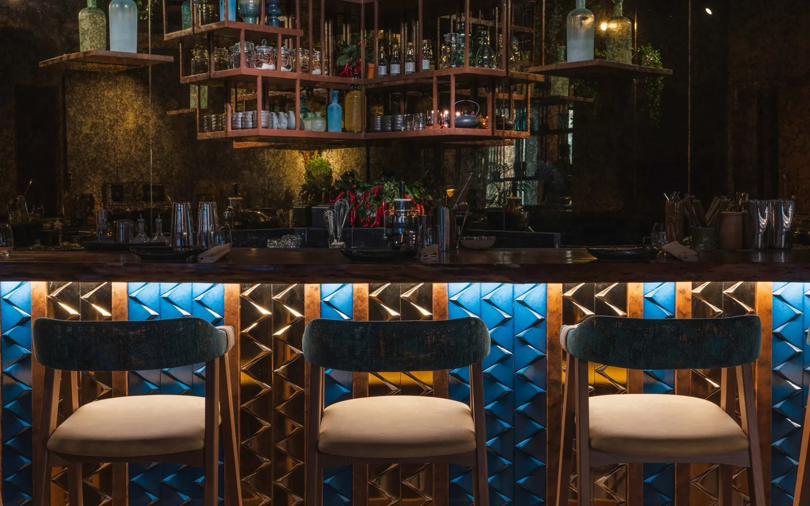 Kuuru's bar, bottles lit above a blue tiled counter.