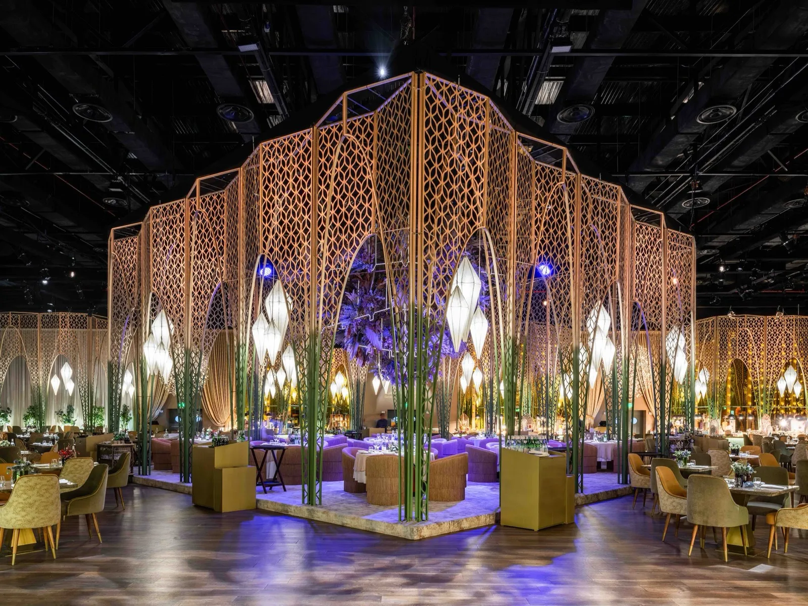 Gold lattice pavilion lit for an evening event.