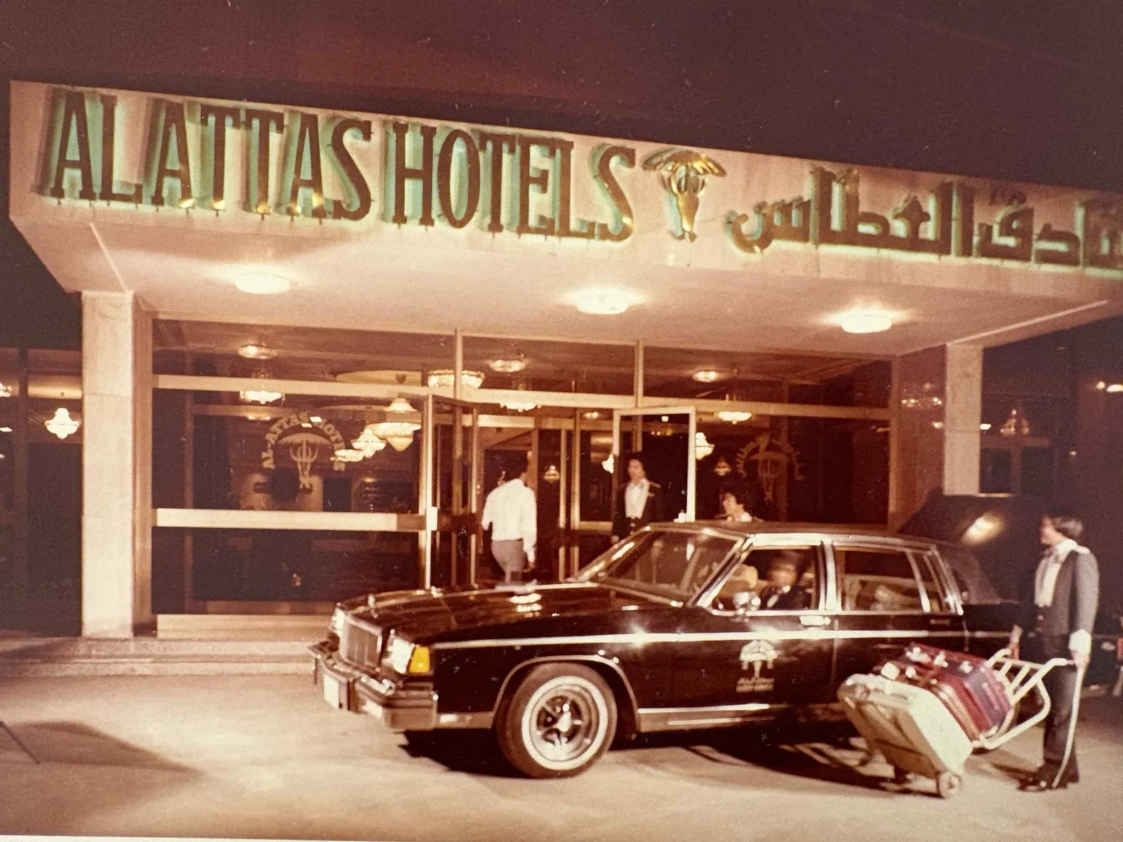 Vintage photograph of a hotel entrance with a classic car.