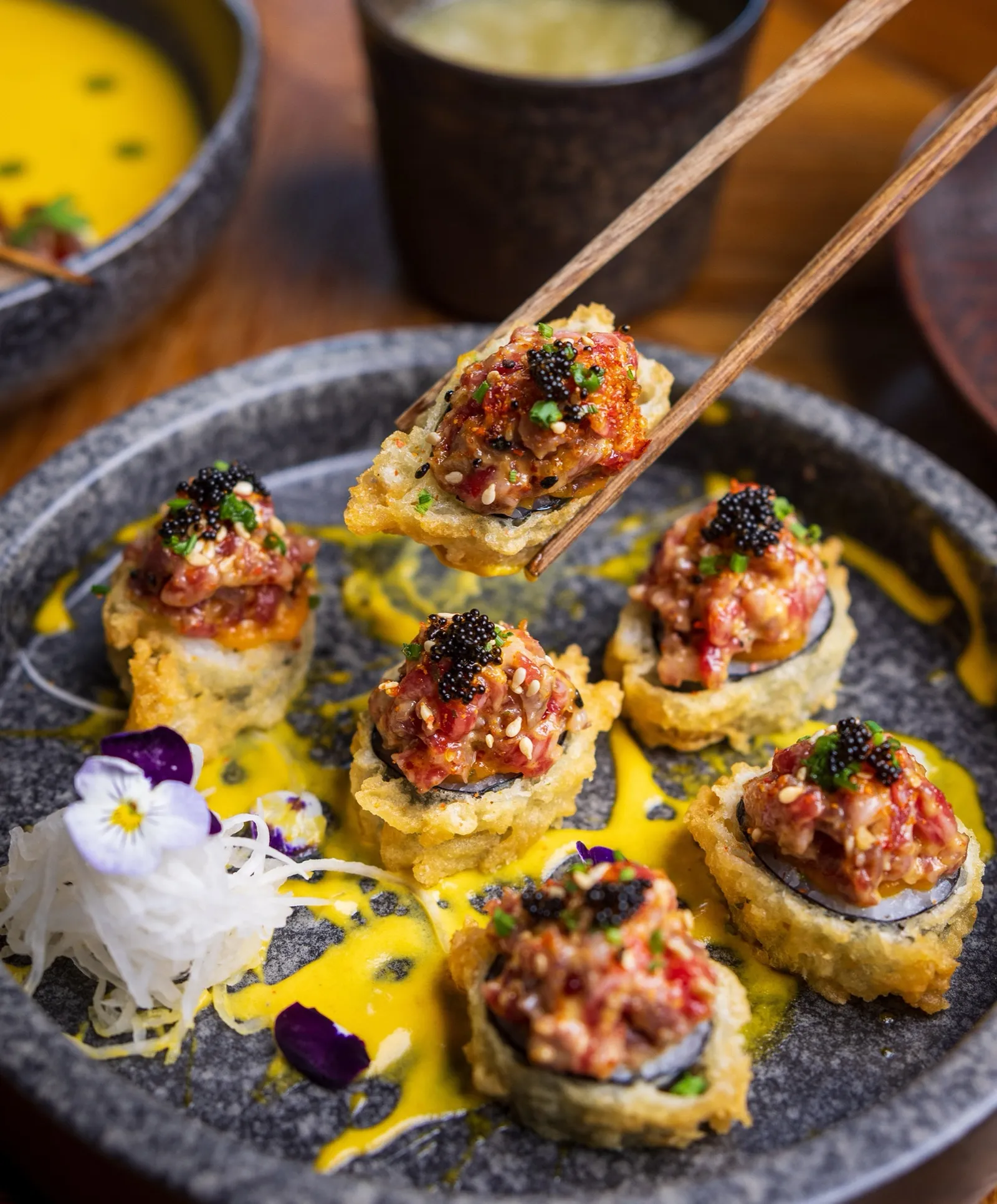 Canapés topped with caviar and edible flowers.